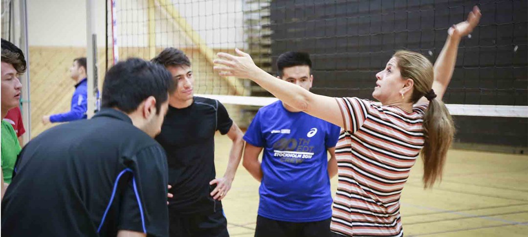 Tränare lär ut en Volleybollserve till ungdomar i föreningen
